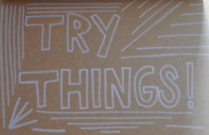 Texte écrit à la main  : « Try things ».