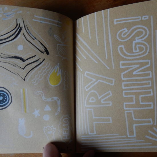 Cahier. Sur la page de gauche, on peut voir des doodles (petits dessins). Sur la page gauche, on peut lire « Try things » avec des lignes.